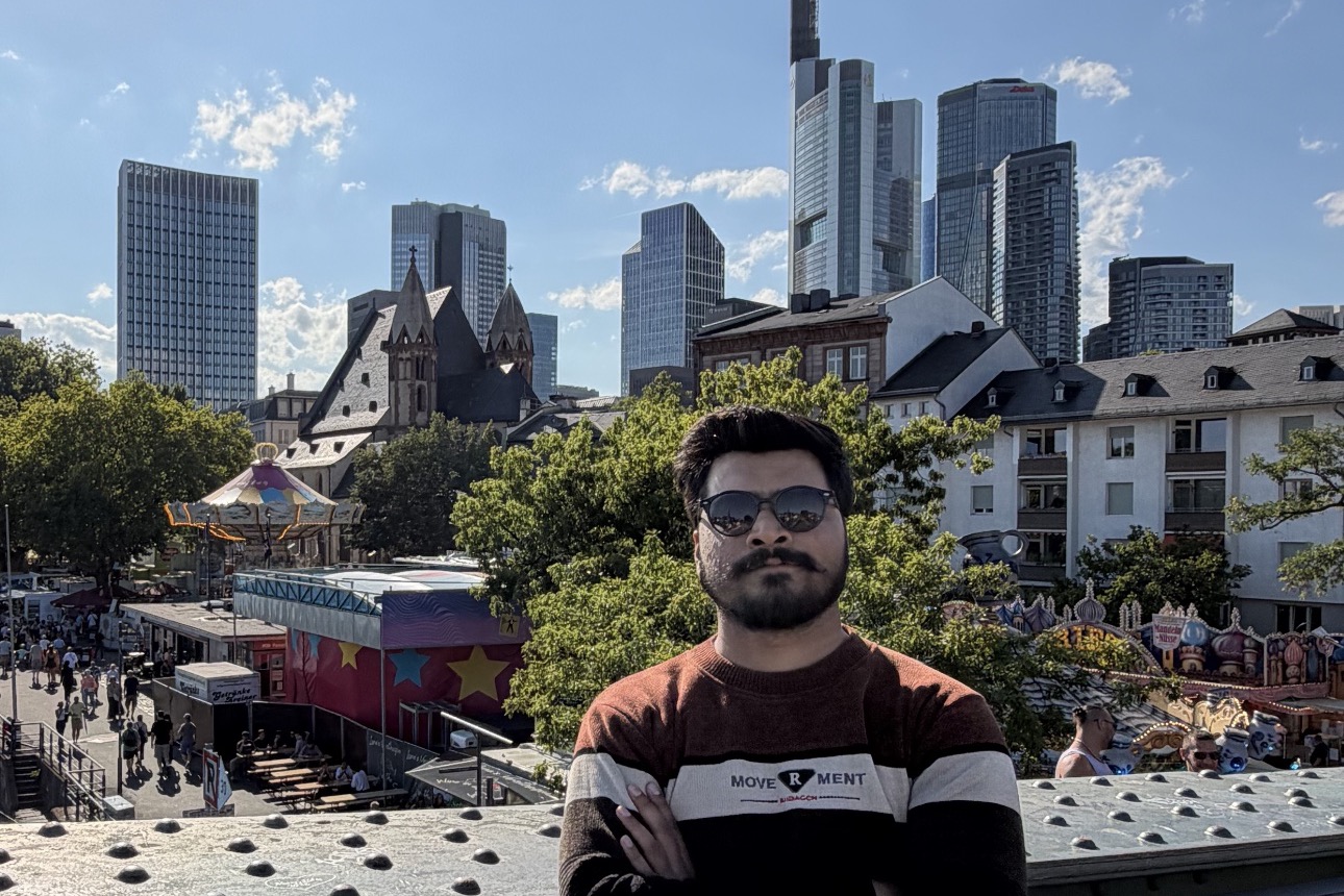 Muhammad Ahmad standing on the Eiserner Steg bridge with the Frankfurt skyline behind him